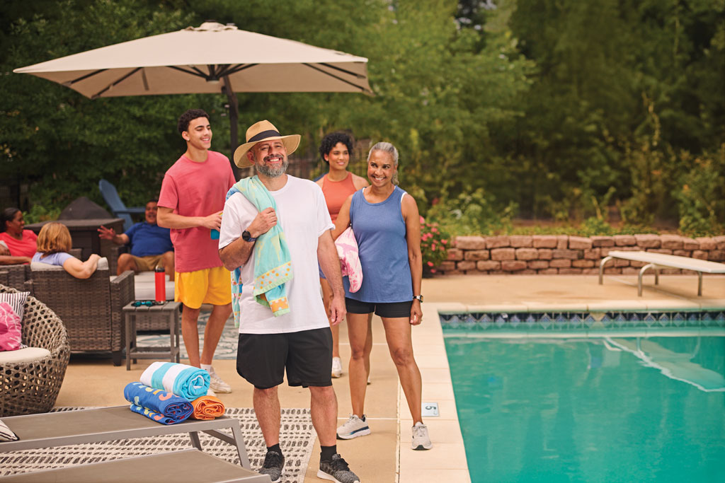 Family standing next to a swimming pool